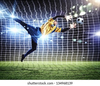 Goalkeeper catches the ball . At the stadium, in the spotlight. - Powered by Shutterstock