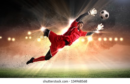 Goalkeeper catches the ball . At the stadium, in the spotlight. - Powered by Shutterstock