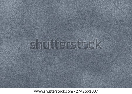Gray suede fabric background with matte nap velvet texture. Graphite tones and soft felt textile surface in macro.