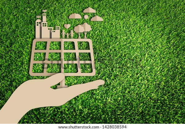 Green city. Paper art style of\
eco on green grass background. Energy saving. Save the\
earth.