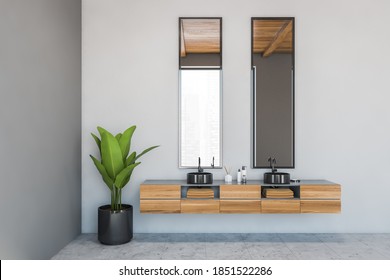 Grey Bathroom With Two Sinks And Wooden Drawers With Brown Towels Inside. White Room With Two Black Washbasins And Plant, 3D Rendering No People