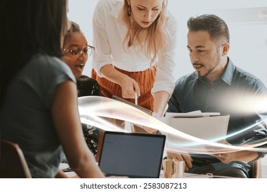 Group of diverse professionals collaborating at a table, with laptops and documents, engaged in a team discussion, focused on teamwork and cooperation. Creative business people in casual meeting.