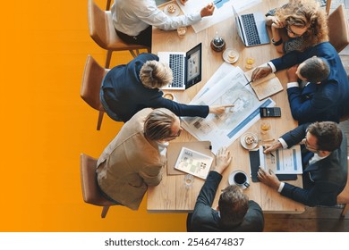 Group of professionals in a business meeting, discussing plans and using laptops. Collaborative team working on a project, sharing business strategies in meeting. Diverse business meeting concept. - Powered by Shutterstock