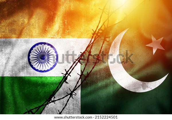 Grunge flags of India and Pakistan divided by barb wire\
sun haze illustration, concept of tense relations between India and\
Pakistan 