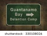 Guantanamo Bay detention camp road sign with directional arrow, illustration with distressed ominous background