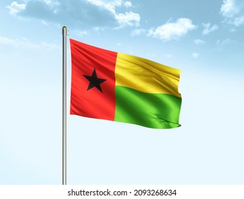 Guinea-Bissau flag waving on blue sky background with clouds. Close up waving flag of Guinea-Bissau. Guinea-Bissau flag waving in the wind. - Powered by Shutterstock