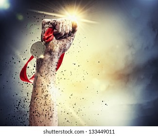 Hand held medal against a stormy sky - Powered by Shutterstock