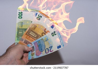 hand helding three burning euro bank notes inflation in the finance market
