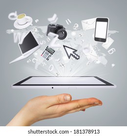 Hand holding tablet pc. Electronics are emitted from the screen tablet. The concept of electronics