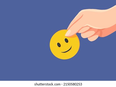 Hand holding yellow paper cut smile face on blue background, positive thinking, mental health assessment , world mental health day concept.drawing - Powered by Shutterstock