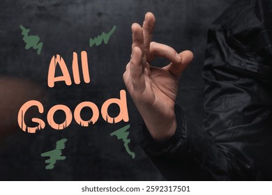 Hand is making an OK gesture with the text All Good and abstract scribbles. Showcasing a positive sign and communication concept
