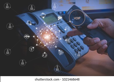 Hand of man using ip phone with flying icon of voip services and people connection, voip and telecommunication concept