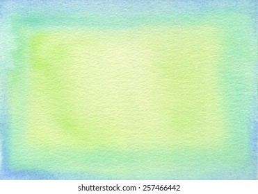 Hand-painted watercolor frame with light blue, green and yellow green tones, on rough-textured watercolor paper. 