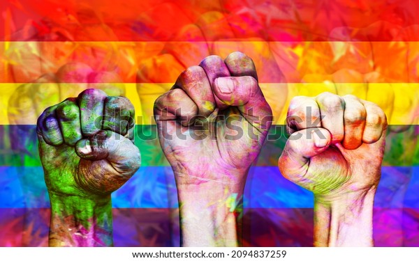 Hands\
clenched into a fist against the background of the rainbow LGBT\
flag. The concept of tolerance and acceptance of homosexuality and\
same-sex love. Equal rights for sexual\
minorities.