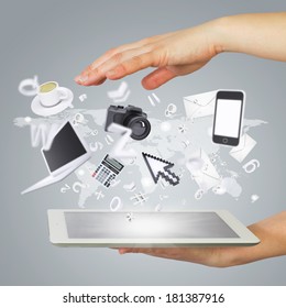 Hands holding tablet pc. Electronics are emitted from the screen tablet. The concept of electronics