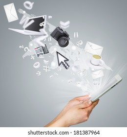 Hands holding tablet pc. Electronics are emitted from the screen tablet. The concept of electronics