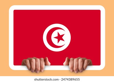 Hands holding a white frame with Tunisia flag, protest or social issues in Tunisia, independence day idea, celebration or campaigning concept, two hands and frame - Powered by Shutterstock