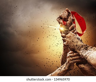 Hands tighten medal in a dark stormy sky. - Powered by Shutterstock