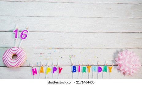 Happy birthday card with number 16. Pink donuts with decorations for a happy birthday from candles - Powered by Shutterstock