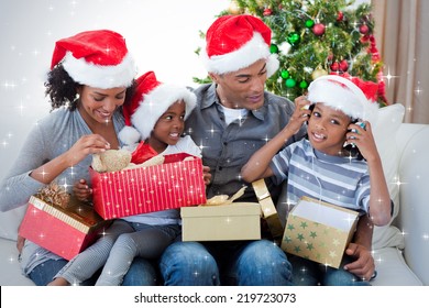 Happy family playing with Christmas presents against snow - Powered by Shutterstock