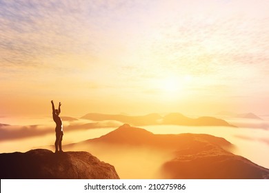 Happy man with hands up on the top of the world, above clouds and mountains. Success, winner, bright future