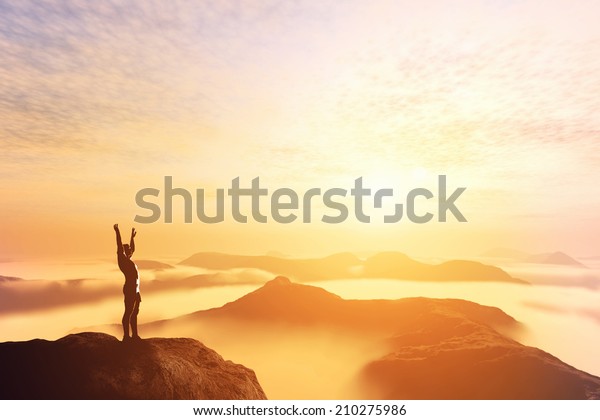 Happy man with\
hands up on the top of the world, above clouds and mountains.\
Success, winner, bright\
future