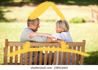 Happy retired couple sitting on the bench against house outline - Powered by Shutterstock