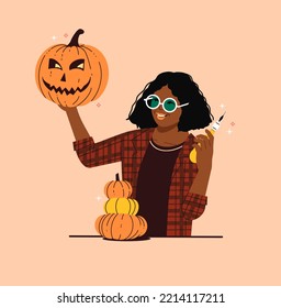 Happy Woman Holding Pumpkin Carving Knife And Carved Pumpkin - Fun Halloween Autumn Activity - Black Girl With Cozy Fall Pumpkin Carved Face