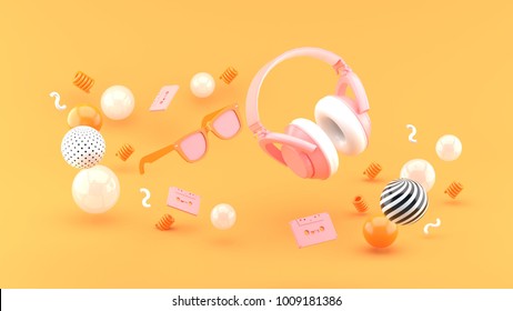 Headphones and glasses float between the balls on the orange background 3d render