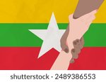 Helping hand against the Myanmar flag. The concept of support. Two hands taking each other. A helping hand for those injured in the fighting, lend a hand
