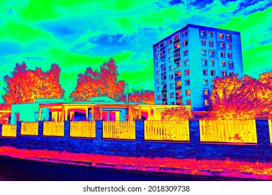 High flat house behind family house in Infrared thermovision scan showing lack of thermal insulation. Infra or thermography photo 