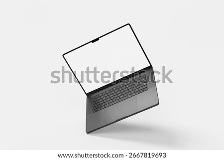 High-angle view of a sleek, dark gray laptop with a clean white screen, casting a soft shadow on a minimalist light gray background. Ideal for technology and design mockups.