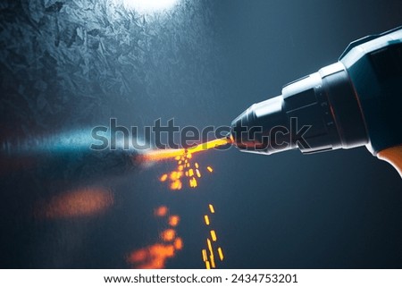 High-powered precision drill bit in action, showcasing advanced industrial machinery as it generates an intense orange glow while penetrating a durable metallic surface.
