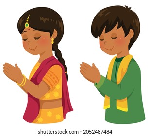 Hindu boy and girl in traditional Indian outfits praying on Diwali.