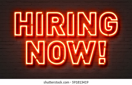 Hiring now neon sign on brick wall background