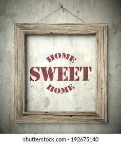 Home Sweet Home Emblem In Old Wooden Frame On Aged Wall