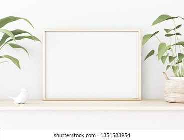 Horizontal poster mockup with golden metal frame standing on wooden table and decorated with green plants in basket on empty white wall background. 3D rendering, illustration.