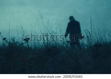 A horror concept. Looking up through grass in a field at a scary supernatural entity with glowing eyes. On a moody evening.