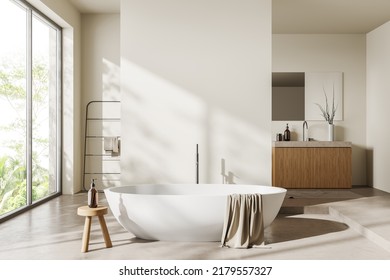 Hotel Bathroom Interior With Bathtub, Sink And Towel Rail Ladder, Podium And Beige Concrete Floor. Panoramic Window On Tropics. Mockup Copy Space Empty Wall. 3D Rendering