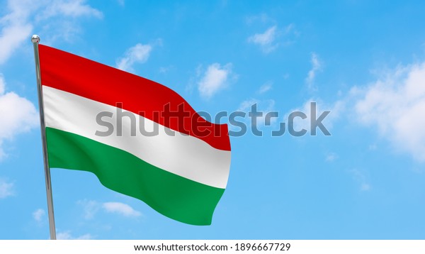 Hungary\
flag on pole. Blue sky. National flag of\
Hungary
