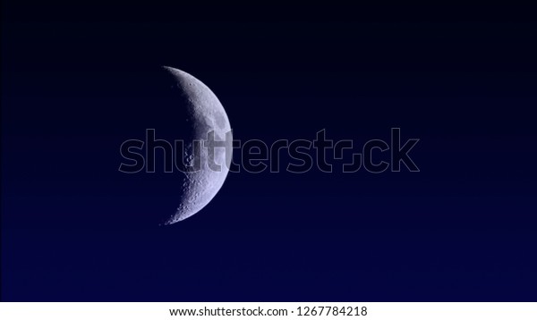 Illustration of bright gibbous\
crescent moon on gradient dark blue clear night space sky\
background