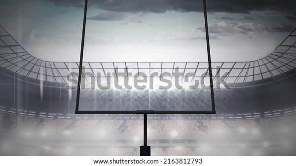 Image of american football goalposts and cloudy\
sky at floodlit stadium. sports, competition, american football\
concept digitally generated\
image.