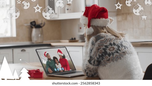 Image of christmas decorations over happy caucasian woman in santa hat on laptop image call. christmas, tradition and celebration concept digitally generated image. - Powered by Shutterstock