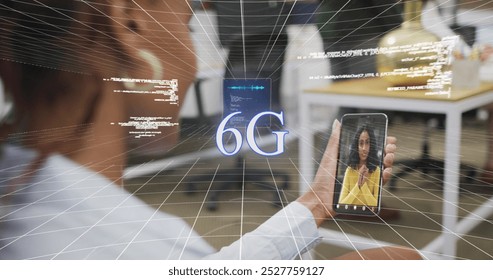 Image of data processing over african american woman having a imagecall on smartphone at office. Global networking and business technology concept - Powered by Shutterstock