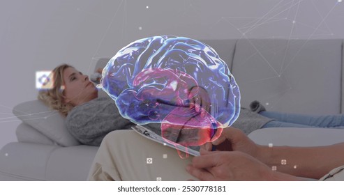 Image of digital brain over caucasian woman consulting psychologist. Mental health, therapy and healthcare concept digitally generated image. - Powered by Shutterstock