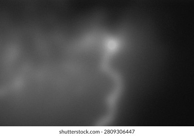 The image features a faint, luminous orb hovering amidst a dense, dark, and cloudy backdrop. The orb emits a soft, ethereal glow, contrasting sharply with the surrounding murky and indistinct environment. The overall scene evokes a sense of mystery and otherworldliness, reminiscent of cosmic or atmospheric phenomena. The lack of clear details and the monochromatic palette heighten the enigmatic quality of the image, making it difficult to discern specific elements or context beyond the glowing orb.