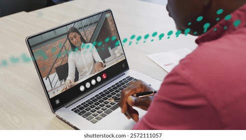 Image of financial data processing over african american man on laptop video call. Global finance, business, connections, computing and data processing concept digitally generated image.