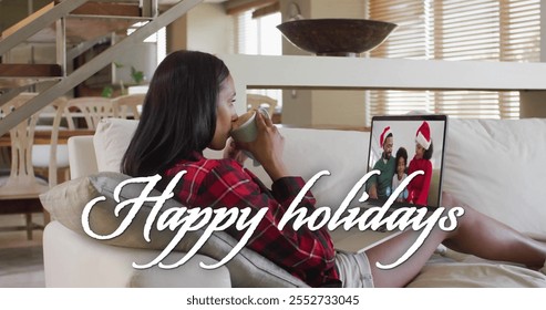 Image of happy holidays text over african american family on laptop screen at christmas. Christmas, festivity, celebration and tradition concept digitally generated image. - Powered by Shutterstock