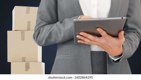 Image of midsection of woman using tablet with stacks of boxes on blue background. global shipping and technology concept digitally generated image.