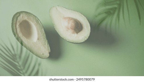 Image of palm tree leaves over halved avocado on green background. Fruit, healthy diet and vegan fresh food concept digitally generated image. - Powered by Shutterstock